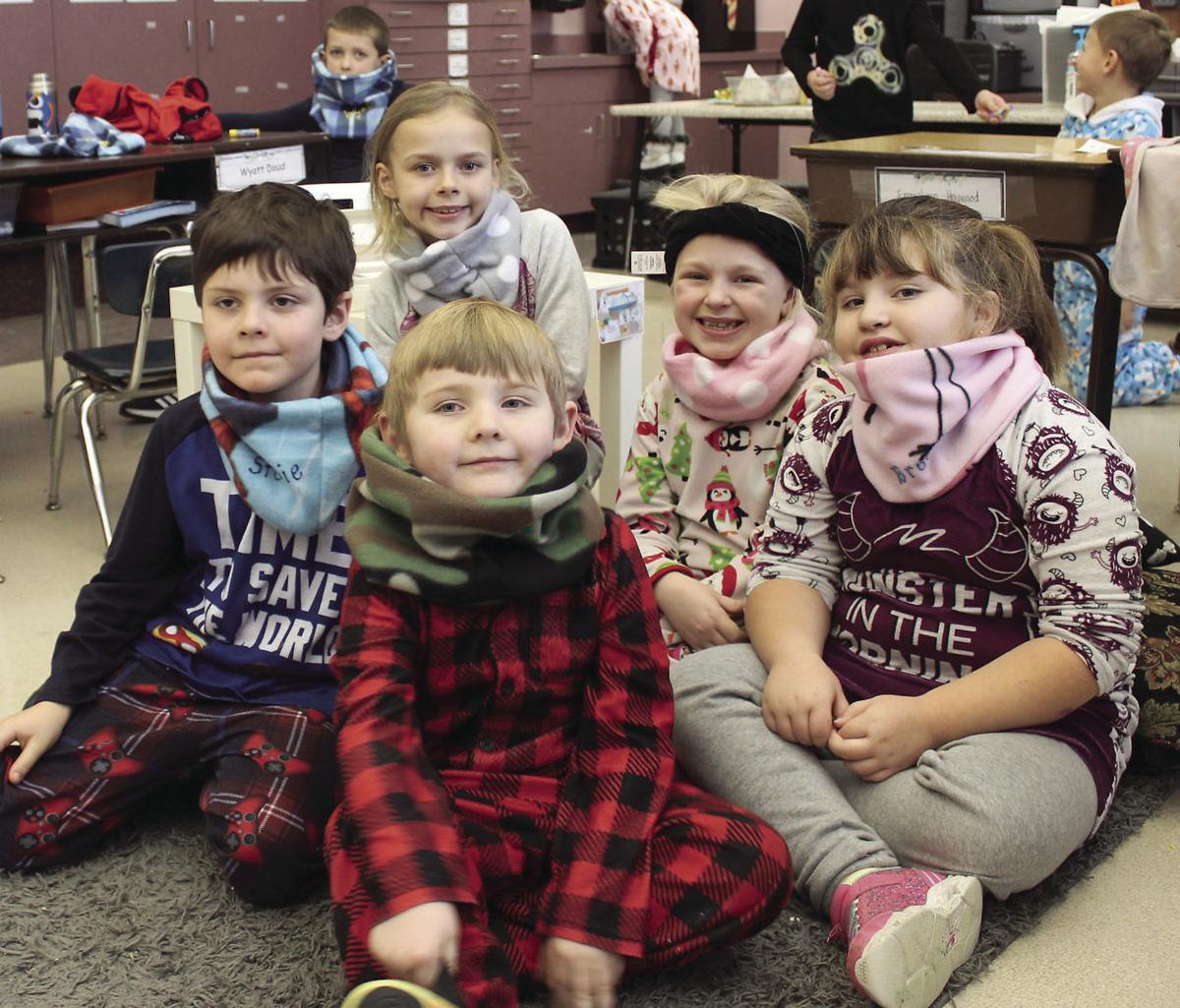 First graders are given handmade neck warmers by teacher