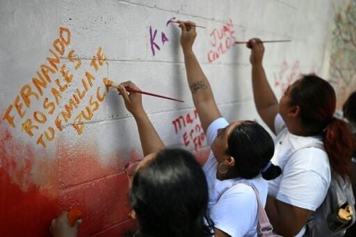 Esmeralda Rosales writes a message addressed to her missing brother, Fernando Rosales, during the inauguration of a mural in tribute to disappeared people, at the University of El Salvador, in San Salvador, on March 19, 2026