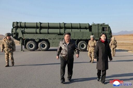 This picture taken on January 27, 2026 and released by North Korea's official Korean Central News Agency (KCNA) on January 28, 2026 shows North Korean leader Kim Jong Un (C) and his daughter Kim Ju Ae (R) inspecting a test firing of the renewed large-ca...
