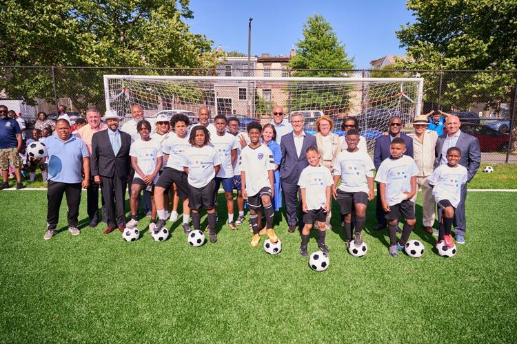 Representatives from Children's Hospital of Philadelphia, Embassy of the United Arab Emirates, Philadelphia Parks and Recreation, gather with community members to celebrate the opening of Conestoga Park soccer field in West Philadelphia.