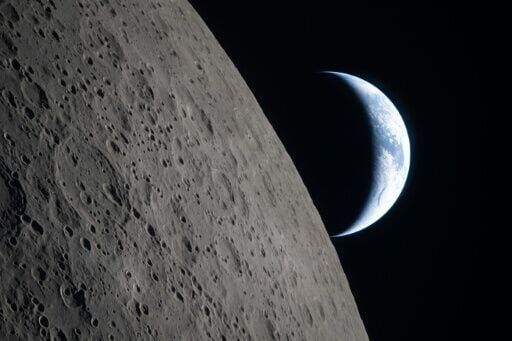 This handout picture released on April 7, 2026, by NASA shows crescent Earth setting along the Moon's limb, as seen from the Orion spacecraft on April 6, 2026