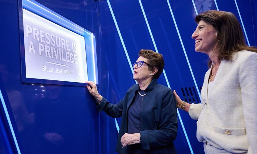 Billie Jean King and Lara Abrash at the 'Pressure Is A Privilege' sign in the player entrance tunnel at Arthur Ashe Stadium.