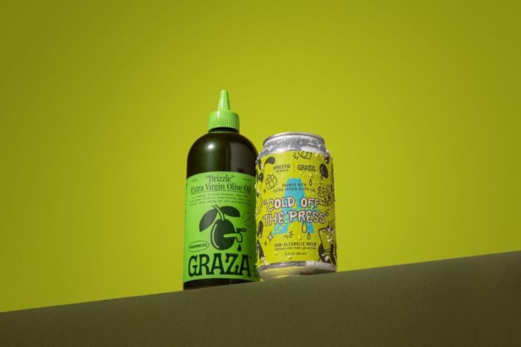 Athletic Brewing Company and Graza have teamed to launch "Cold Off The Press," a limited-time non-alcoholic collaboration brew made with Graza Extra Virgin Olive Oil. Adding extra virgin olive oil during the brewing process doesn’t make it olive oil-fla...