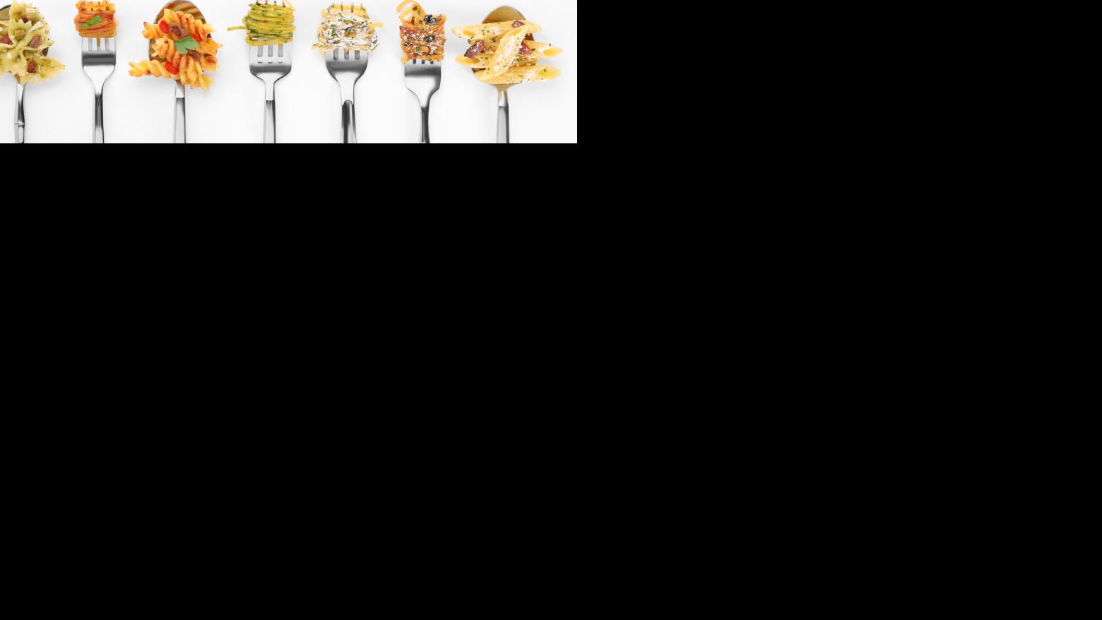 STOCK Forks and spoons with various tasty pasta on white background, flat lay. Space for text