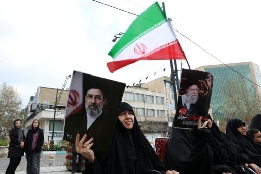 Iranian women hold portraits of Iran's supreme leader Mojtaba Khamenei (R) and Iran’s slain supreme leader Ayatollah Ali Khamenei (L) while gathering in front of Tehran's Mellat park on April 2, 2026