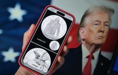 A phone displaying the commemorative gold coin featuring Trump to mark America's 250th anniversary