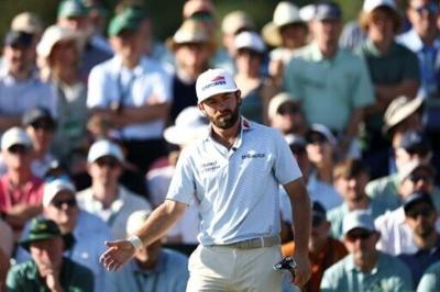 Third-round co-leader Cameron Young acknowledges fans on the 18th green at Augusta National