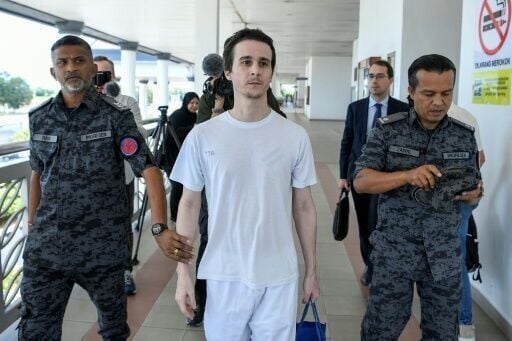 French national Tom Felix walks with Malaysian immigration officers after he was acquitted on eight drug-related charges in Malaysia