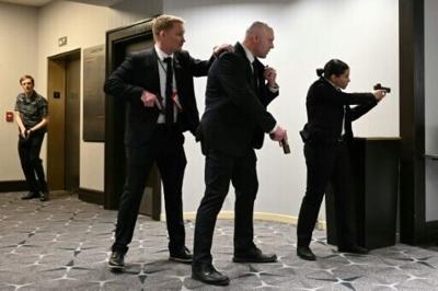 Agents draw their guns after loud bangs were heard during the White House Correspondents' dinner at the Washington Hilton in Washington