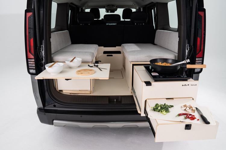 VanLab - Tailgate kitchen and rear dining. Pull out drawers reveal the exterior kitchen all under the cover of the tailgate roof. Allowing for effortless food prep and elevated outdoor dining. Using the vehicle V2L allows for electric hot plate and elec...