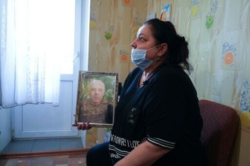 Iryna Levchykov, Bohdan's mother -- who has cancer -- holds a photo of her husband Stanislav, who was killed defending Kharkiv