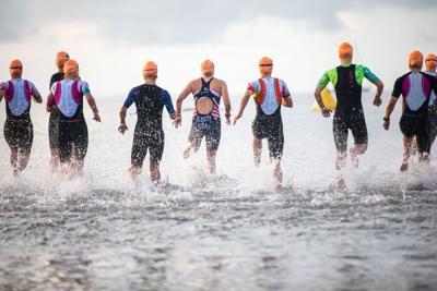 Several athletes run into the water to prepare for the swim leg of the 2026 St. Anthony’s Triathlon in April.