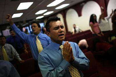People pray during a service in a storefront church in the Little Havana neighborhood of Miami, Fla.