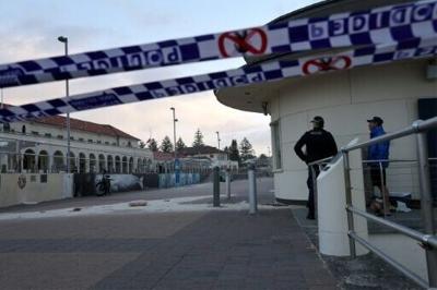 A police officer speaks with a lifeguard at the scene of the shooting at Bondi Beach in Sydney