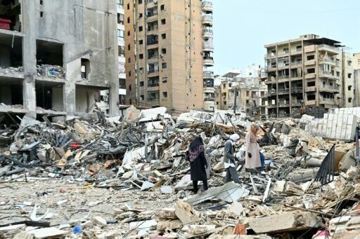 Women check on the destruction as they return to their neighbourhood in Beirut's southern suburbs