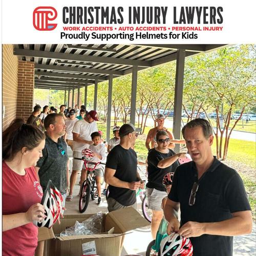 Attorney Gary Christmas and staff pitching in to make sure kids are safe during a recent 'Helmets for Kids' event.