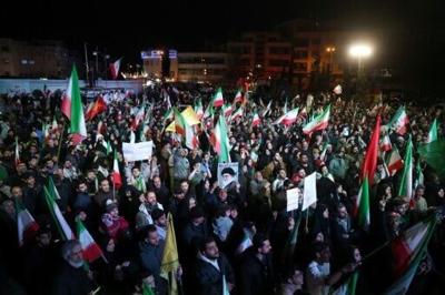 Iranians react after a ceasefire announcement at the Enqelab square in Tehran