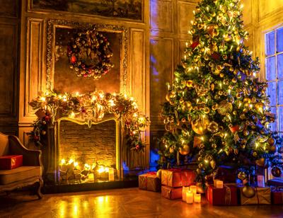 Christmas and New Year interior decoration. Green tree decorated with toys, gifts, present boxes, flashing garland, illuminated lamps. Fireplace and xmas tree. Cozy Christmas atmosphere