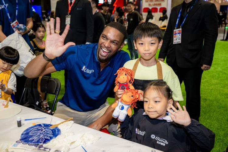 NBA legend Chris Bosh engages with members from local social service organisations at the Community Basketball Carnival, adding to the warm and uplifting atmosphere.