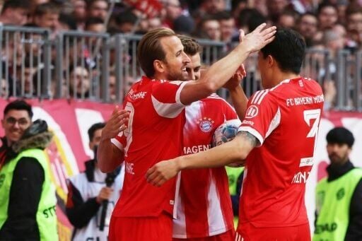 Bayern Munich striker Harry Kane (L) celebrates as his side beat Stuttgart to claim another Bundesliga title