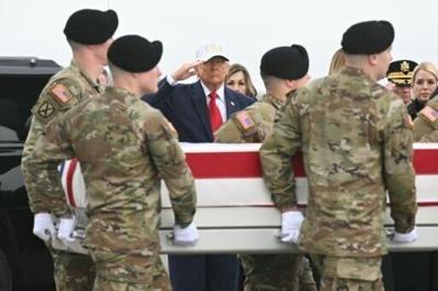 US President Donald Trump salutes as the remains of Sergeant First Class Noah Tietjens, killed in the war with Iran, arrive at Dover Air Force Base on March 7, 2026