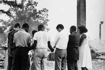 Members of the Student Nonviolent Coordinating Committee pray beside the ruins of a burned church near Dawson, Ga., in 1962.