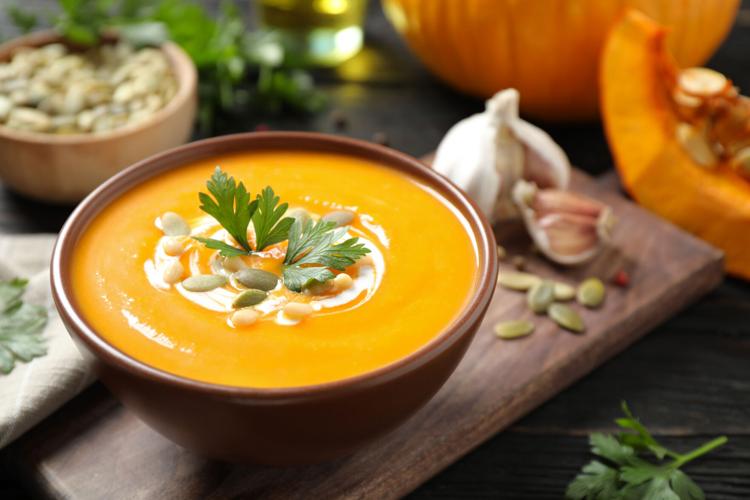 Stock Delicious pumpkin soup in bowl on wooden table