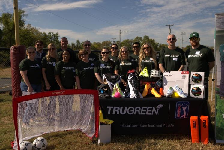 TruGreen volunteers gather around new sports equipment donated to the local community through the company’s partnership with Good Sports and iHeartMedia.