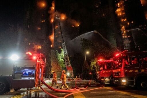 Firefighters spray water on flames as a major fire engulfs several apartment blocks at the Wang Fuk Court residential estate in Hong Kong's Tai Po district