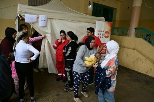 Mariam Zein (R) brings her son to a mobile health clinic run by charity Caritas Lebanon