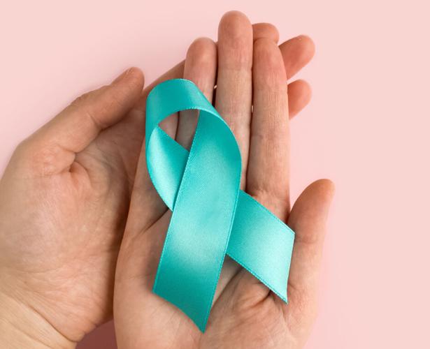 Woman holding Teal ribbon. Symbolic for cervical cancer, ovarian cancer, gynecological cancer and PCOS. And sexual assault awareness.