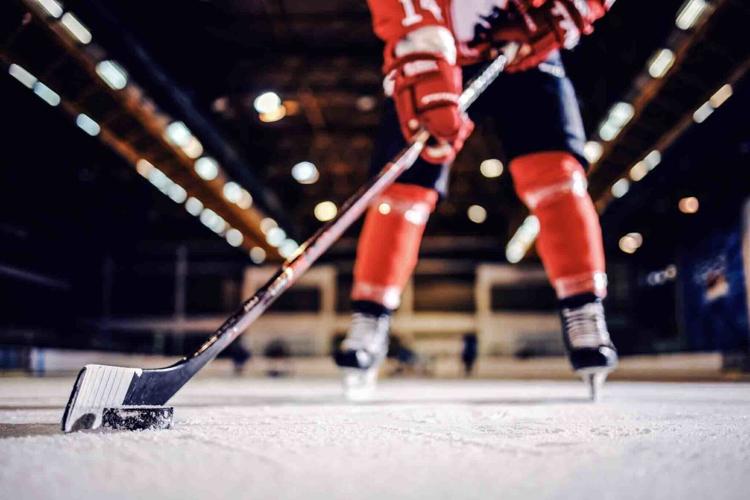 hockey player skating with stick and puck by Dusan Petkovic