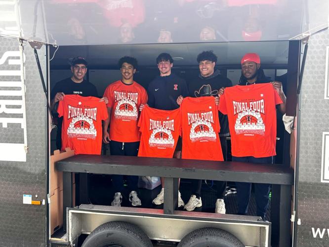 Campus Ink/NIL Store Owner Steven Farag stands in the company's apparel customization trailer with four members of the University of Illinois football team who stopped by to help print some shirts. Farag and his crew are preparing to do much larger on-s...