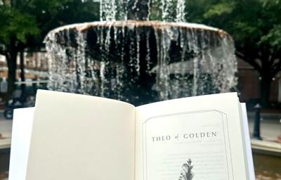 "Theo of Golden" book in front of fountain in Columbus, Georgia