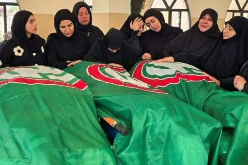 Mourners gather around the bodies of people killed earlier this week by Israeli airstrikes in the Lebanese coastal city of Tyre
