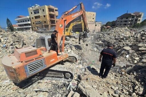 Rescue teams work to remove the rubble of a building hit by the Israeli army in the southern Lebanese village of Hanaouay