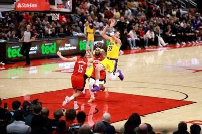 Luka Doncic soars over Reed Sheppard to make a layup in the Los Angeles Lakers' victory over the Houston Rockets