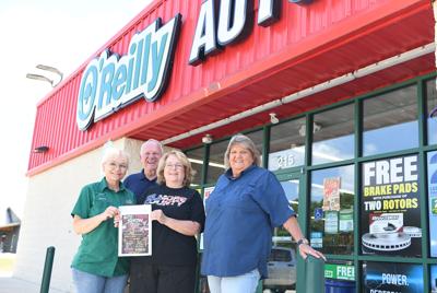 Cliff Williams / TPI Humane Society of Elmore County director Rea Cord, center poses with O’Reilly Auto Parts employees and car show organizers as proceeds from a car show to the humane society.