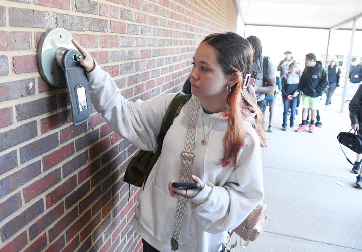 Cliff Williams / TPI Eclectic Middle School students unlock their Yondr pouches before school to put their cell phones in.
