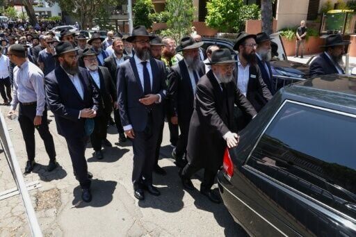 Mourners follow the hearse carrying the coffin of rabbi Eli Schlanger, who was killed in the December 14 Bondi beach shooting attack, after his funeral service at the Chabad of Bondi Synagogue in Sydney on December 17, 2025