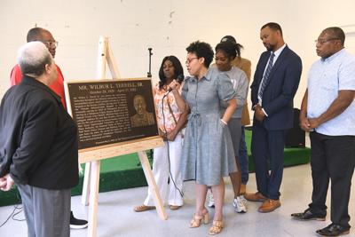 Cliff Williams / TPI Tandra Terrell, a granddaughter of Wilbur Terrell Sr. reads the plaque as part of the ceremony recognizing Terrell’s effort over the decades in the Wall Street community.
