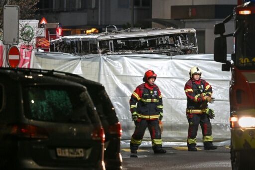 Firefighters at the scene of the bus blaze in Kerzers. Swiss police believe the fire may have been started deliberately