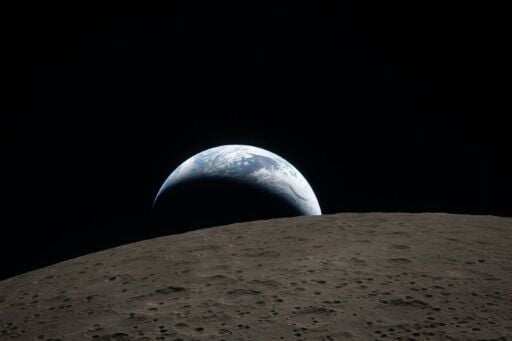 This handout picture from NASA shows Earth as it dips beyond the lunar horizon, as seen from the Orion spacecraft that is shuttling Artemis II astronauts on a historic mission around the Moon