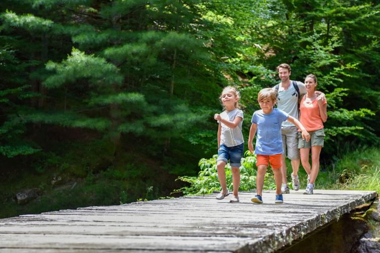 Family of four walking on a bridge crossing the river