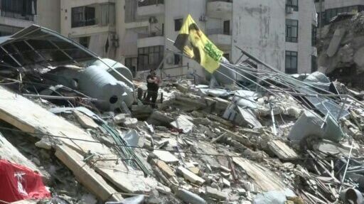 Hezbollah supporters in south Beirut wave flags from rubble after ceasefire