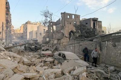 People walk past rubble at the site of an Israeli air strike in Beirut's Bashoura neighbourhood