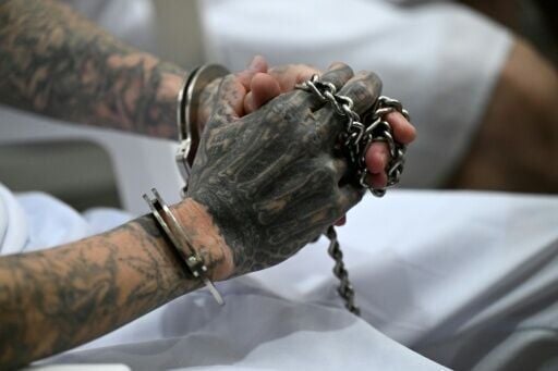 Un miembro de la Mara Salvatrucha (MS-13) encadenado y esposado durante una vista judicial a distancia por videoconferencia en el Centro de Confinamiento del Terrorismo (CECOT) de Tecoluca, El Salvador, el 23 de abril de 2026