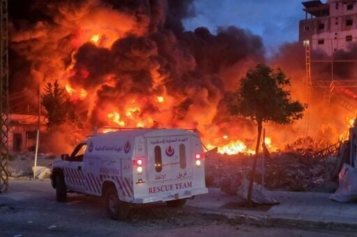 An ambulance is parked near a sweeping blaze following Israeli bombardment on a solar farm and electricity generation facility in Lebanon's southern coastal city of Tyre