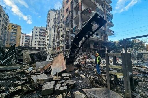 Men inspect a site of overnight Israeli airstrikes in the southern suburbs of Beirut on March 16, 2026