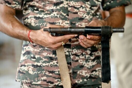 Security officer holds a gun seized from a Maoist fighter